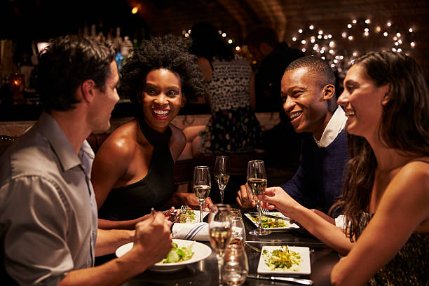 istock Two Couples Enjoying Meal In Restaurant Together 508293512