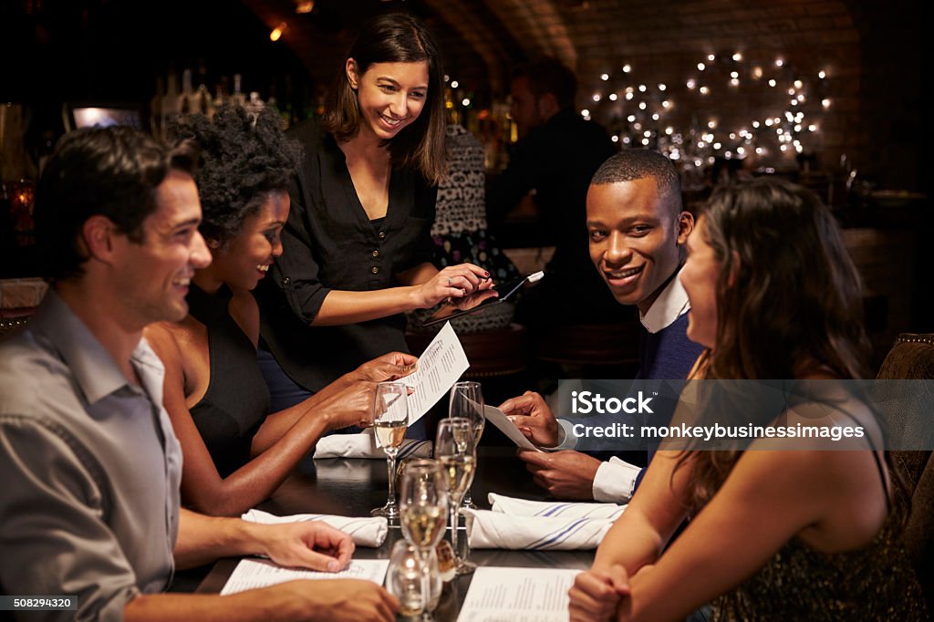 Waitress Takes Order In Restaurant Using Digital Tablet - Royaltyfri Restaurang Bildbanksbilder