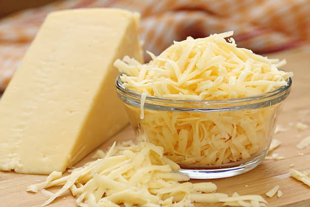 Grated cheese in a glass bowl Grated cheese in a glass bowl shredded stock pictures, royalty-free photos & images
