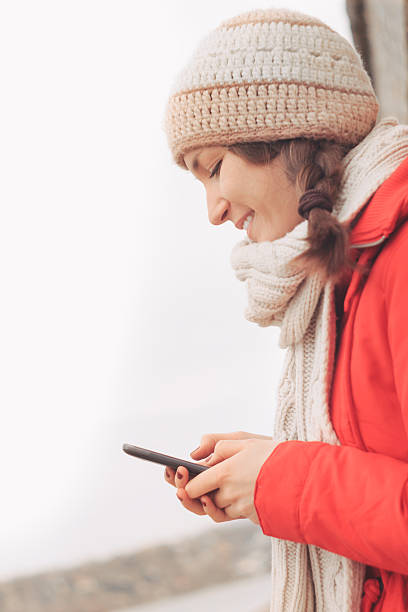 istock Young woman using mobile phone in winter 508298434