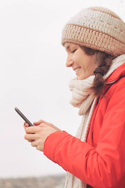 istock Young woman using mobile phone in winter 508298524