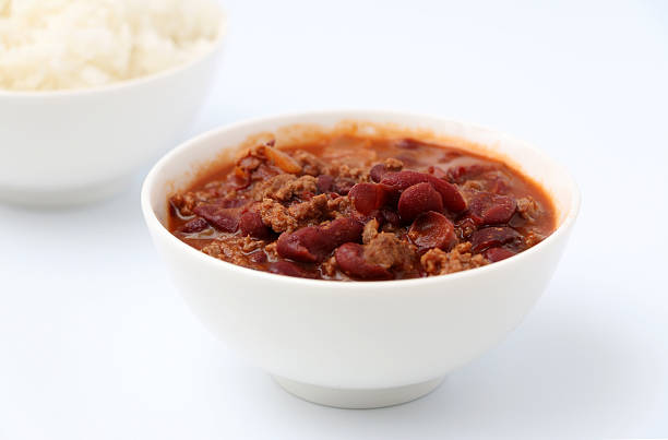 Bowl of chili with a bowl of rice in the background