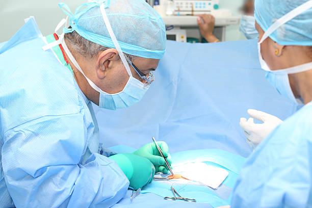 Doctor making a suture in operation room Doctor making a suture in operation room hernia photos stock pictures, royalty-free photos & images