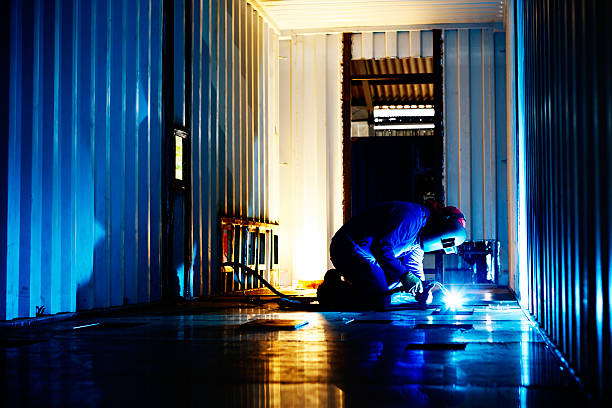 istock Welder busy modifying a cargo container in steel fabrication plant 508302041
