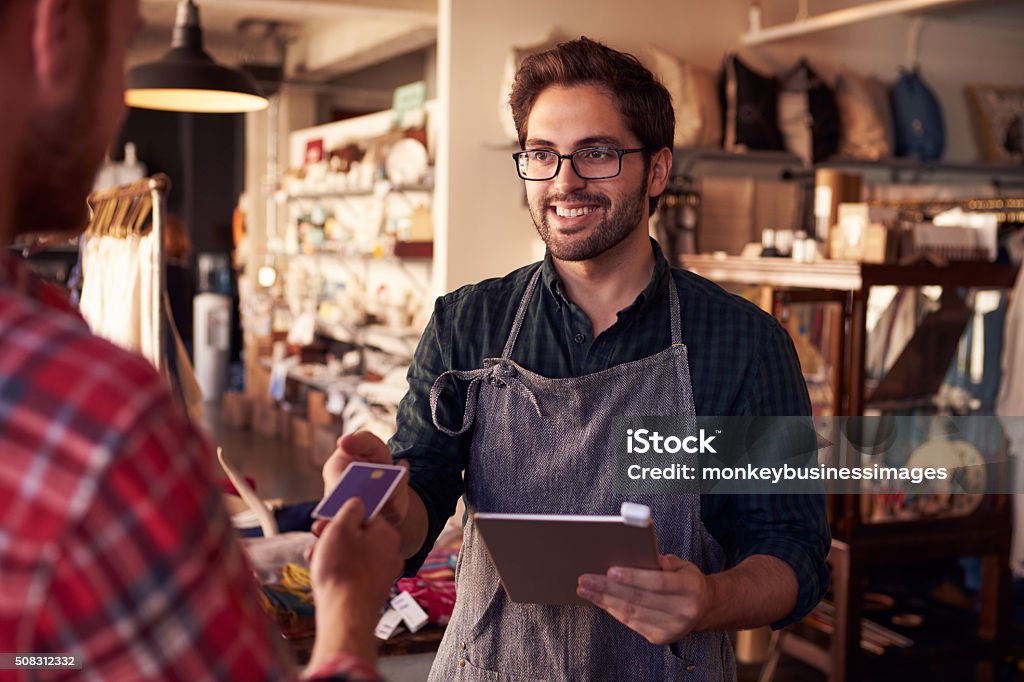 Assistante commerciale avec lecteur de carte de crédit sur tablette numérique - Photo de Magasin libre de droits