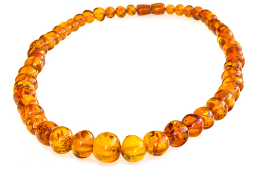 Photo necklace made of amber on white background done in a home studio, using and daylight