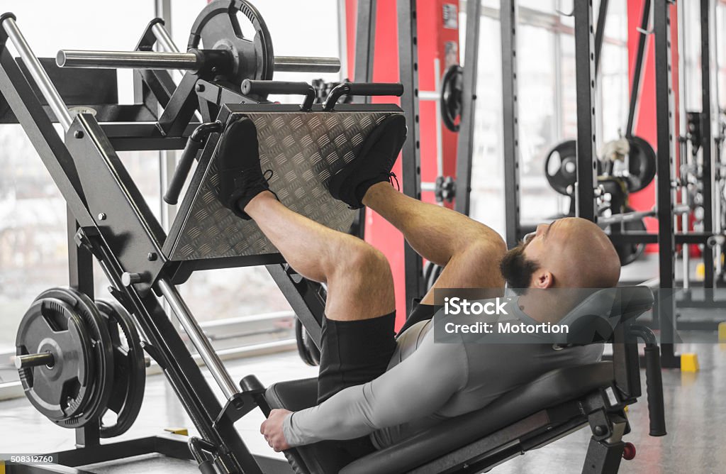 Atleta profissional fazendo perna rotina do dia na academia, a preparação - Foto de stock de Perna humana royalty-free