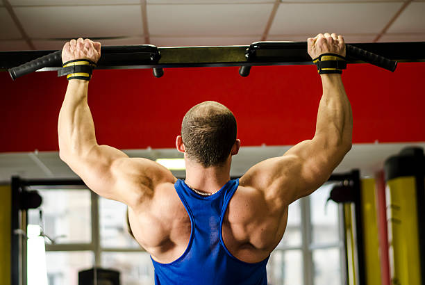 istock Muscular bodybuilder with strong body doing chin-up exercises, training 508312994