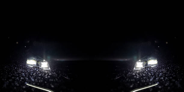 Close-up on a car headlight at night time. Rainy weather