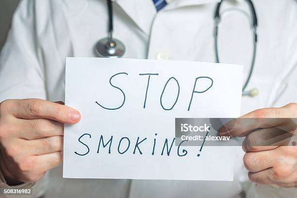 Doctor Holds A Clipboard With Stop Smoking Label Stock Photo - Download Image Now - Addiction, Adult, Anti Smoking