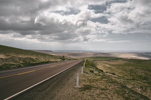 Road through the peruvian desert near the Pacific Ocean