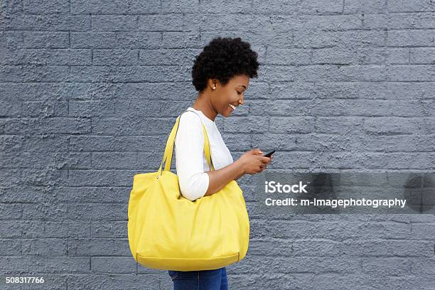 Glückliche Junge Frau Liest Nachricht An Mobiltelefon Stockfoto und mehr Bilder von Unterwegs