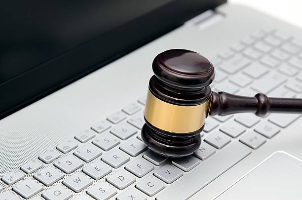istock Wooden judge hammer on laptop computer white keyboard 508318750