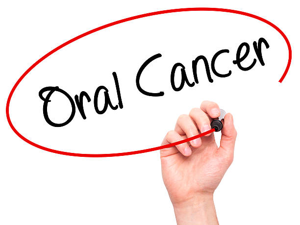 istock Man Hand writing Oral Cancer with black marker 508319490