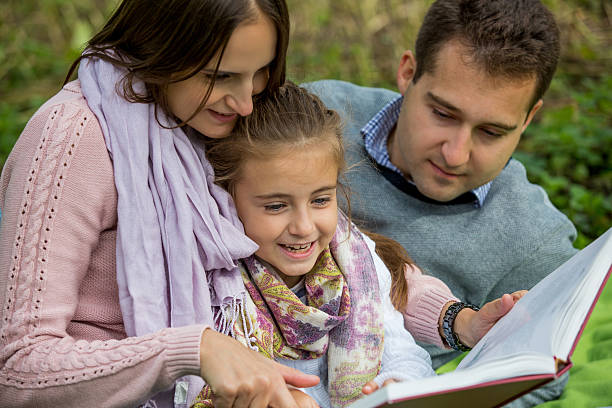istock Young beautiful family sitting with big book 508320908