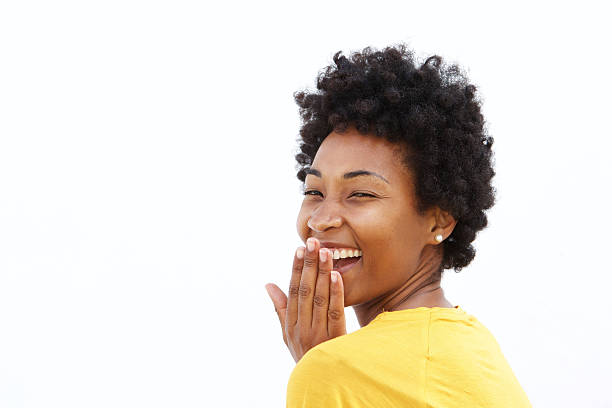 young woman covering her mouth and laughing - hand voor de mond stockfoto's en -beelden