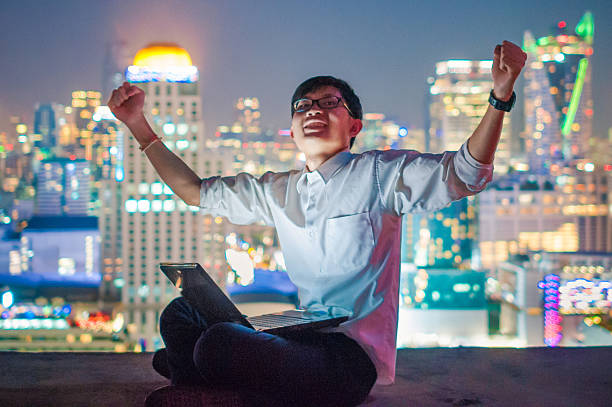 istock Businessman using a laptop on the rooftop of a skyscraper 508325310