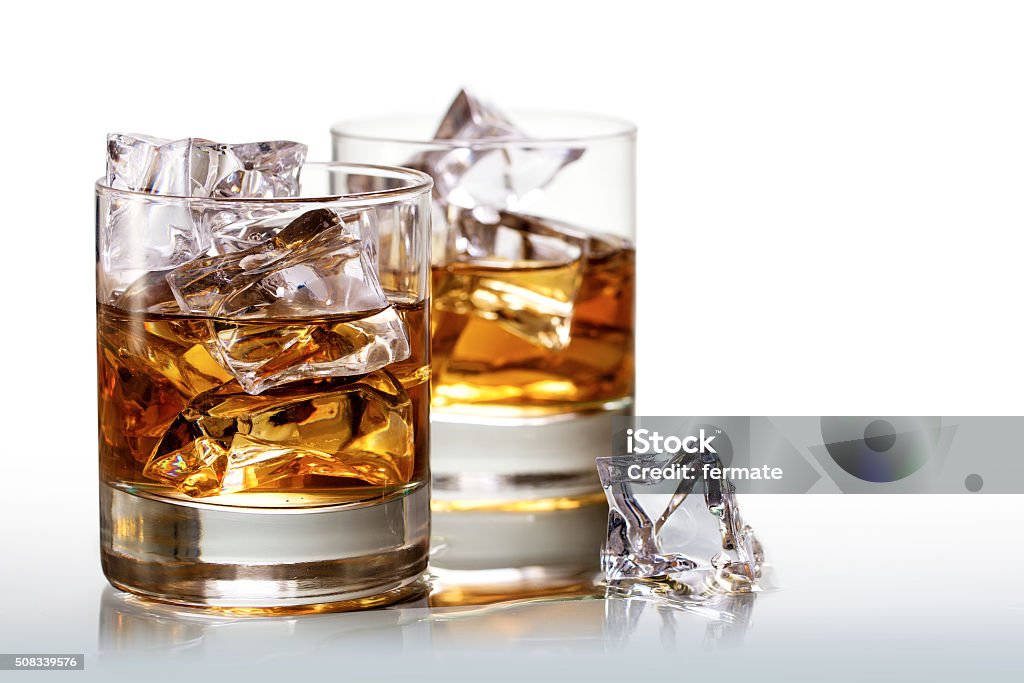 glasses of whiskey with ice cubes, background fades to white Two glasses of scotch whiskey with ice cubes, background fades to white, copy space Drinking Glass Stock Photo