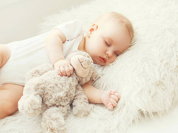 bebê fofinho dormir na cama em casa suave - material data sheets imagens e fotografias de stock