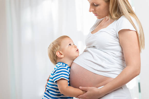 istock Kid boy hugging pregnant mother's belly 508341228