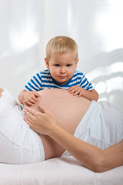 istock Kid boy hugging pregnant mother's belly 508341676