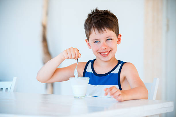 istock Smiling little boy eating delicious yogurt 508345746