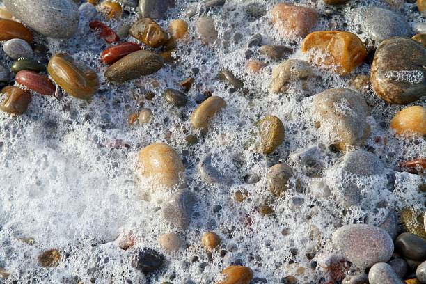 istock close up of multi coloured pebbles and surf on beach 508346640