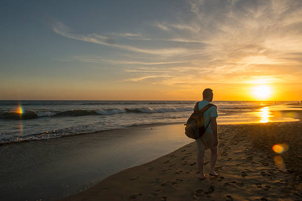 Man walking the beach at sunset at Maspalomas beach, Gran Canaria,Spain