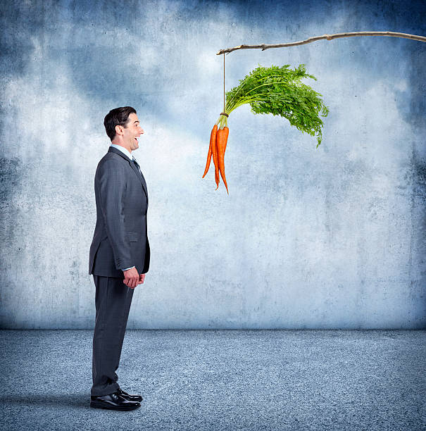 istock Businessman Excitedly Looking At A Dangling Carrot On A Stick 508347148