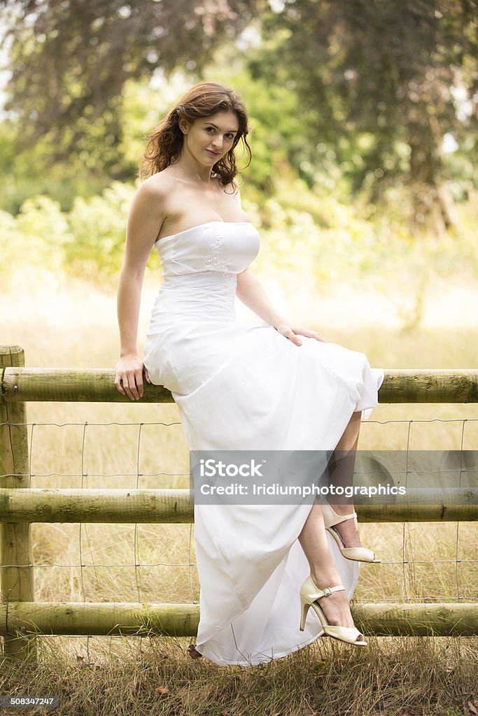 Brunette in a wedding dress A beautiful brunette girl in a white wedding dress, taken outdoors using natural light. Adult Stock Photo