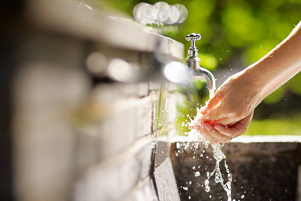 Woman washing hands in a city fountain Closeup photo of woman wash hands in a city fountain whites only drinking fountain stock pictures, royalty-free photos & images