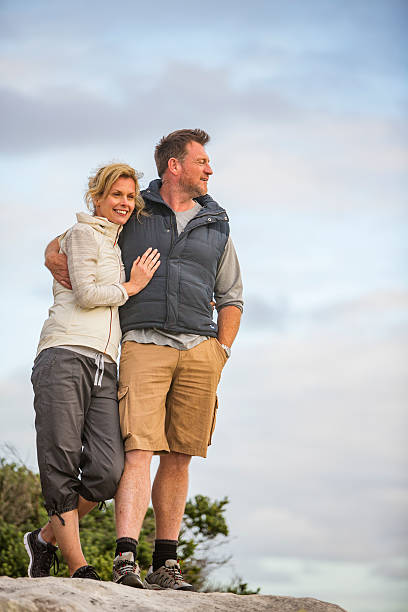 feliz abrazando medio de activa en forma saludable de pareja en la playa al aire libre - couple mature adult action walking fotografías e imágenes de stock