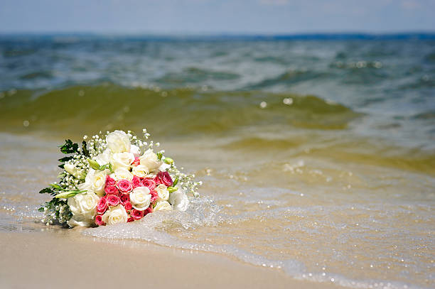 Wedding bouquet lies on the beach