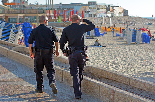 Tel Aviv, Israel - April 7, 2015: Two Israeli Police officers patrol on Tel Aviv beach waterfront. The Israeli Police are a professional force, with some 35,000 persons on the payroll.