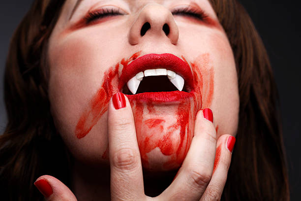 istock Female vampire licking blood 508350719