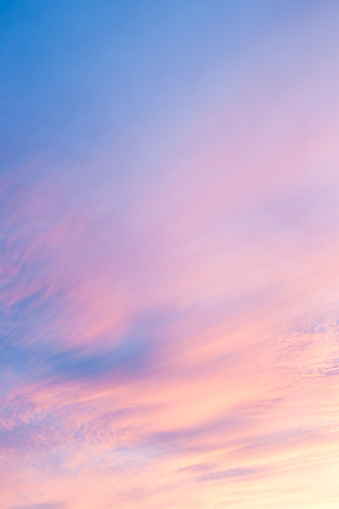 Light whispy cirrus clouds catch the colors of sunset across New Mexico sky.