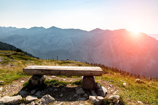 Sunset above the bench at the shore of the lake in mountains in Alps Austria