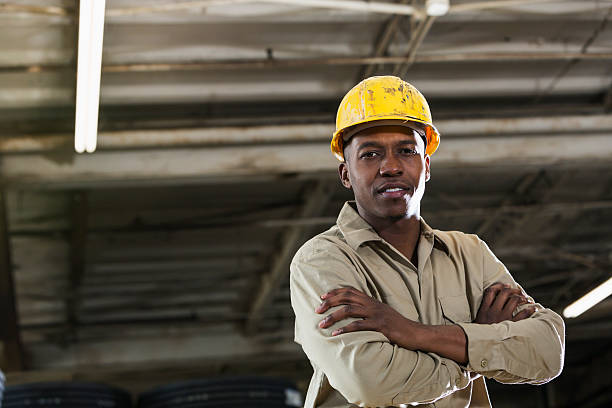 homme afro-américain travaillant dans un entrepôt - minority african ethnicity business hardhat photos et images de collection