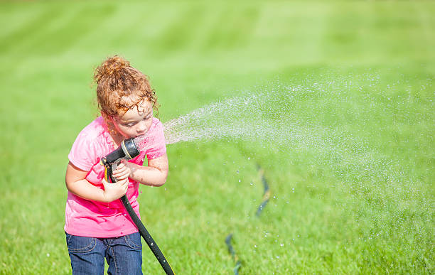 istock Girl Drinking from Garden Hose 508352053
