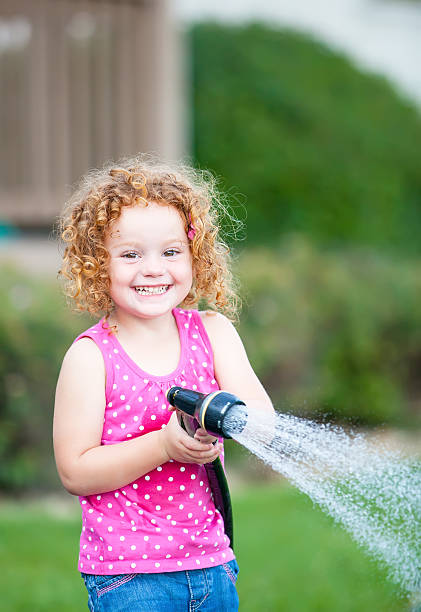 istock Girl Playing With Garden Hose 508352665
