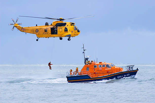 raf elicottero di soccorso e salutano barca di salvataggio in azione - urgent parola inglese foto e immagini stock