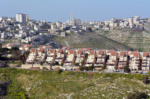 Maale Adumim, Israel - March 25, 2015: View of Maale Adumim settlement against the arab village al-Eizariya. It's the third largest Israeli settlement in the West Bank and a city of 40,000 residence near Jerusalem.