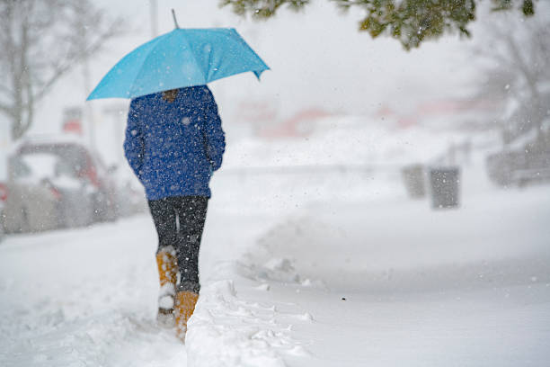 teenager-mädchen mit regenschirm unter schneefall auf der straße - queens head stock-fotos und bilder