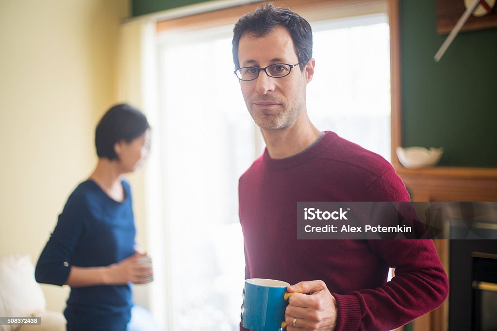 Multi-ethnic family, caucaian man and korean woman, at home Multi-ethnic family, caucaian man and korean woman, at home in the living room. Syracuses, New York State, USA 30-34 Years Stock Photo