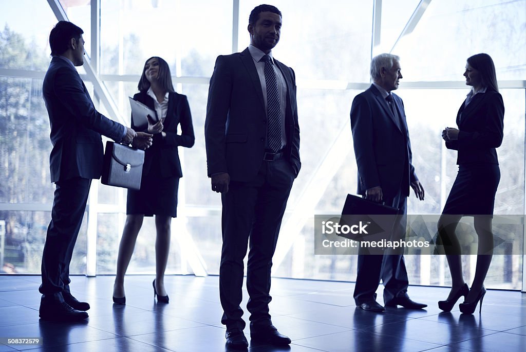 Business people in lobby Business people standing in office lobby, some of them talking 30-39 Years Stock Photo