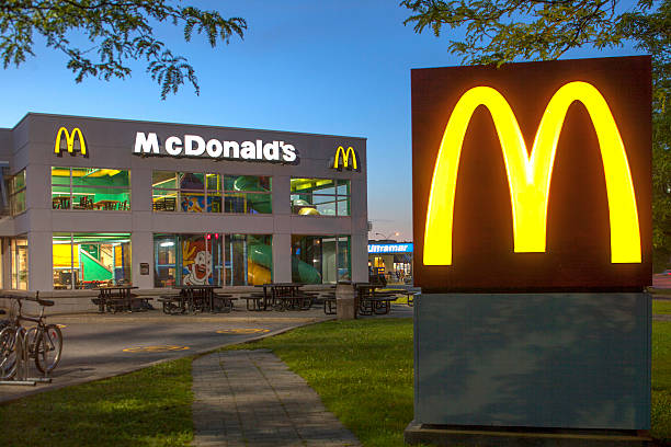 mcdonald's restaurante ao anoitecer - brand name yellow red business imagens e fotografias de stock