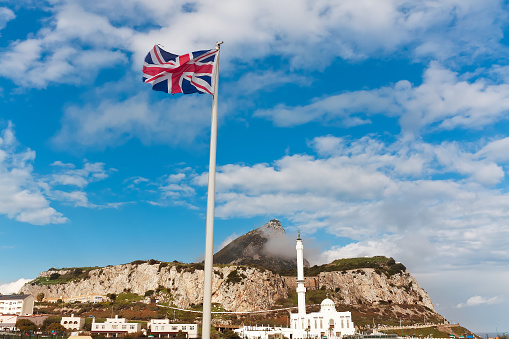 The Union Jack and the flag of Gibraltar flapping in the breeze at the top of the Rock of Gibraltar