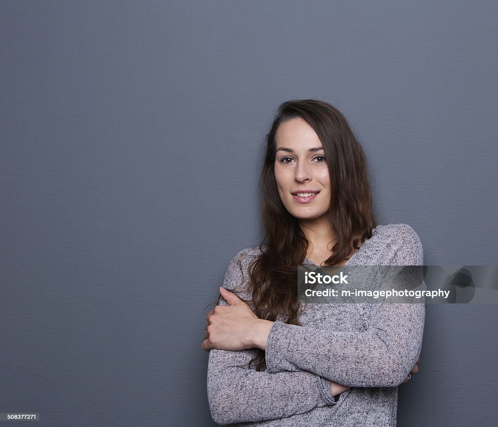 Young woman smiling with cardigan Portrait of a beautiful young woman smiling with cardigan on gray background Women Stock Photo