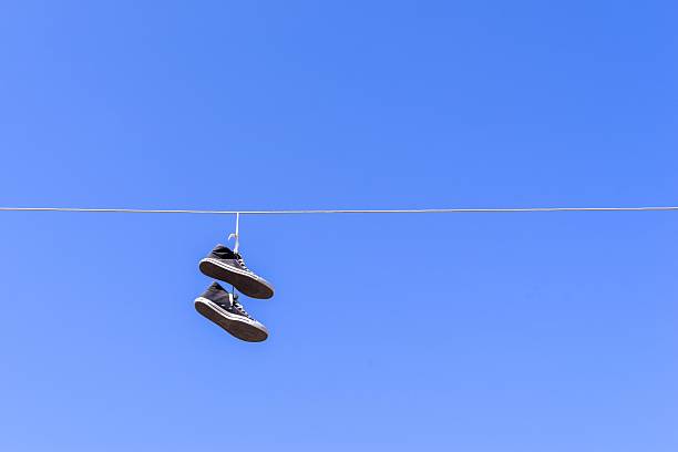 istock old gym shoes on a wire against the blue sky 508377496