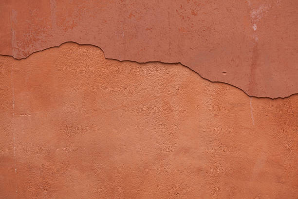 Old terracotta painted stucco wall with cracked plaster. Backgro Old terracotta painted stucco wall with cracked plaster. Background texture. terracotta stock pictures, royalty-free photos & images